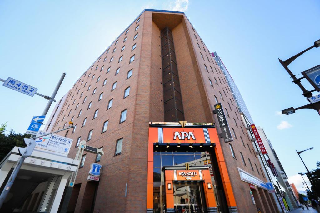 a tall building with an akara sign in front of it at APA Hotel Sapporo Susukino Ekimae in Sapporo