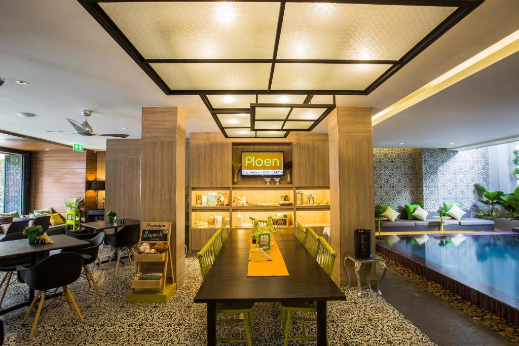 a hotel lobby with a pool and a restaurant at Ploen Chaweng by Tolani in Chaweng