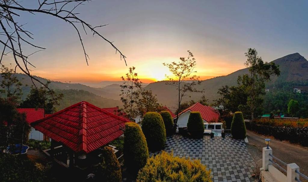 a view of a house with a sunset in the background at Heaven Valley Resorts Vagamon in Vagamon