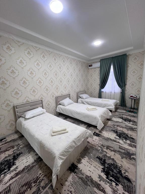 Zimmer mit 3 Betten und einem Fenster in der Unterkunft Apartment 10 минут от Регистана in Samarkand