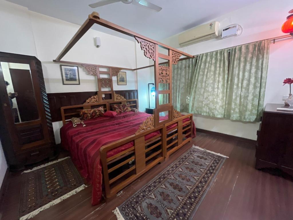 una camera con un grande letto con copriletto rosso di Tangy Apartments a Chennai