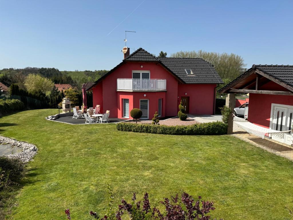 une maison rouge avec une pelouse devant elle dans l'établissement Dům Stašov, à Stašov