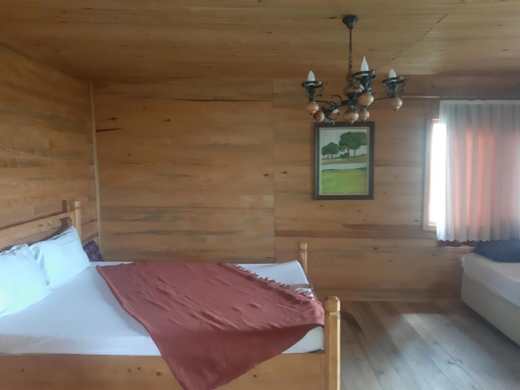 a bedroom with a bed in a wooden room at İda bay bungolow in Edremit