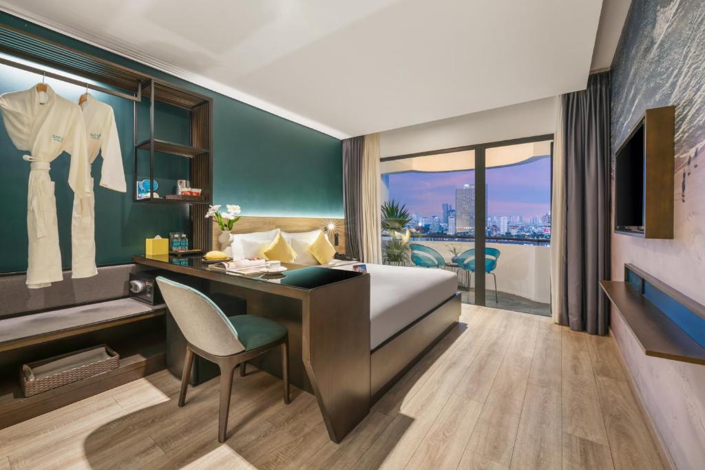 a bedroom with a bed and a desk with a chair at Satya Da Nang Hotel Han Market in Danang