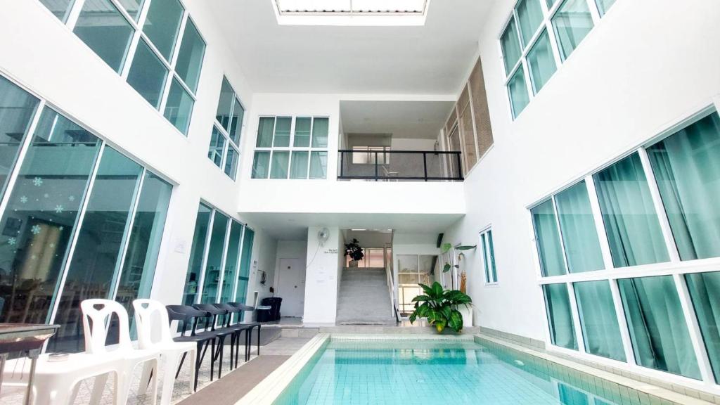 an indoor pool in a building with windows at The Inn10 Pool Villa Pattaya, Entire Villa, 9 Bedrooms, Private Indoor Swimming Pool, ดิ อินน์เท็น in Pattaya Central