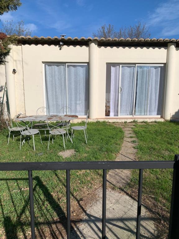 une maison avec une table et des chaises dans la cour dans l'établissement Le flamant rose, à Arles