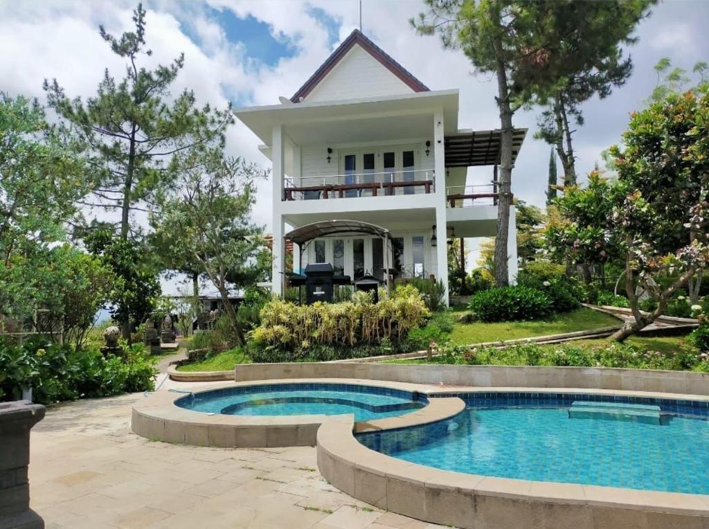 a house with a swimming pool in front of it at Mahesa 1 in Batu