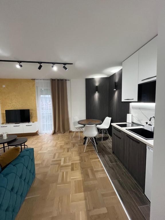 Vrnjačka Banja的住宿－Apartman Daria，厨房以及带桌椅的起居室。