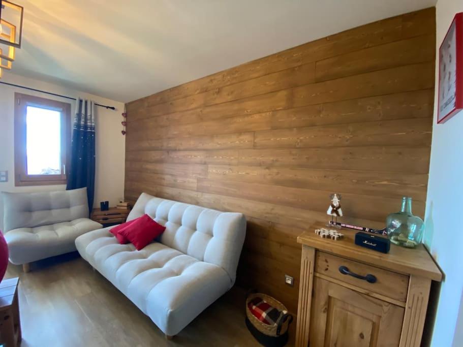 - un salon avec un canapé blanc et un mur en bois dans l'établissement Le Gabiott, Appartement neuf pour 4, au pied des pistes à La Rosière, à Montvalezan
