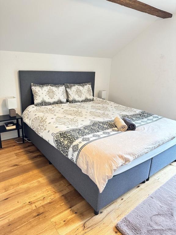 ein Schlafzimmer mit einem großen Bett und Holzboden in der Unterkunft Stilvolle 2,5 Zimmer Wohnung in St. Gallen