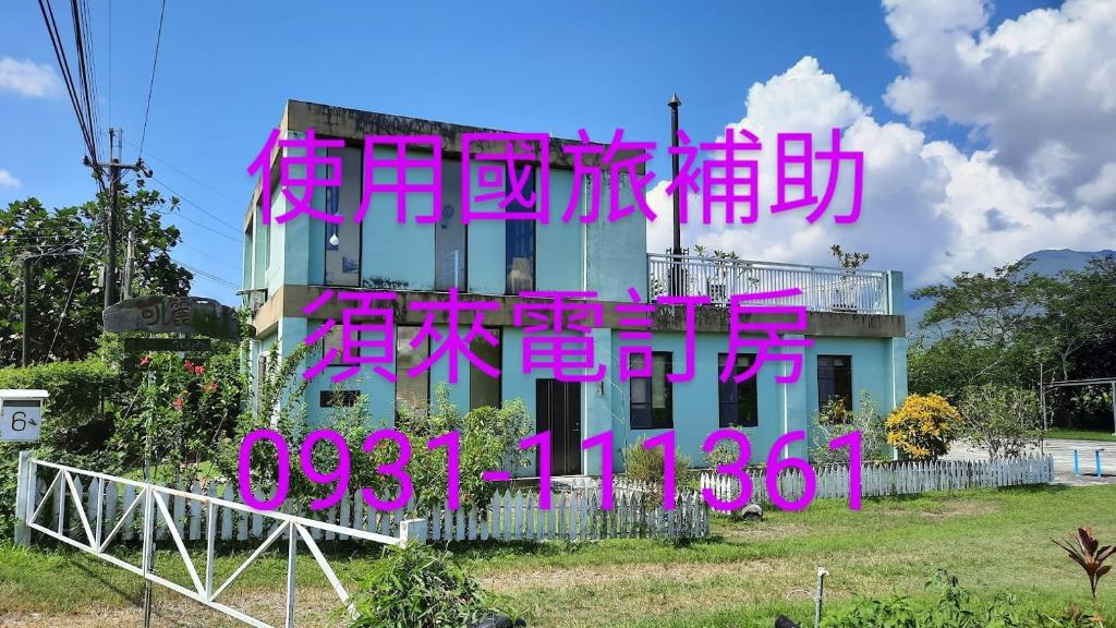 光復鄉的住宿－可麗友善田園渡假民宿，一边有粉红色的书写作品的建筑