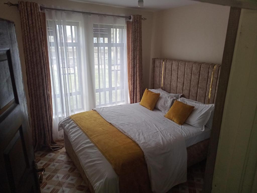 - une chambre avec un lit et 2 oreillers jaunes dans l'établissement The seed, à Nairobi