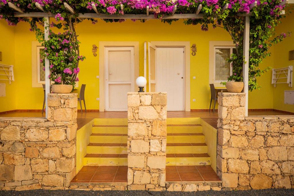 a yellow house with flowers on the walls at Appartamento Percebes. Stella Maris Exclusive in Calheta Do Maio