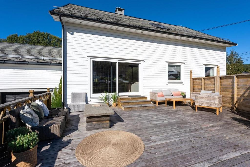 una terraza de madera con muebles y una casa en Aalesund Holiday Home 5 Bedroom! en Ålesund