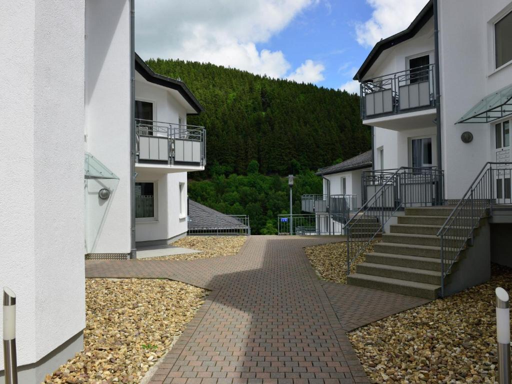 a walkway between two buildings with a mountain in the background at Magnificent Apartment in Willingen with Balcony in Willingen