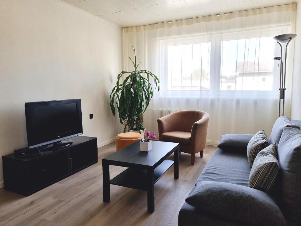 a living room with a couch and a tv at Räpina Apartment in Räpina