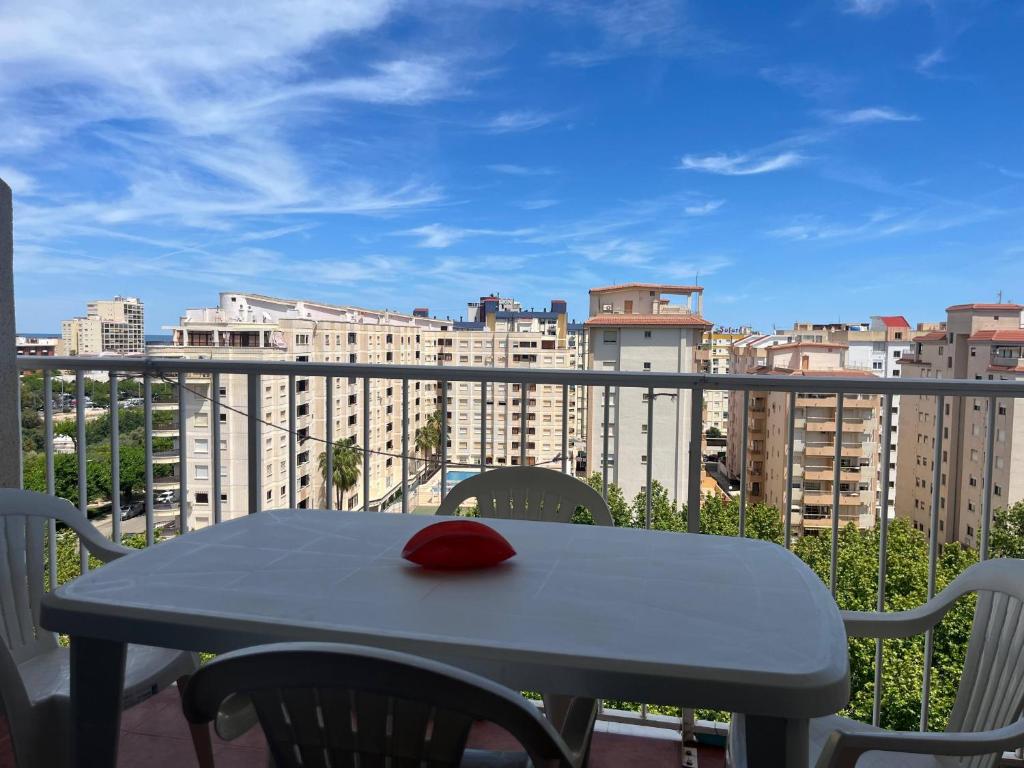 a table with a red hat on top of a balcony at Bitacora VI Solo Familias SERVIPLAYA in Playa de Gandia