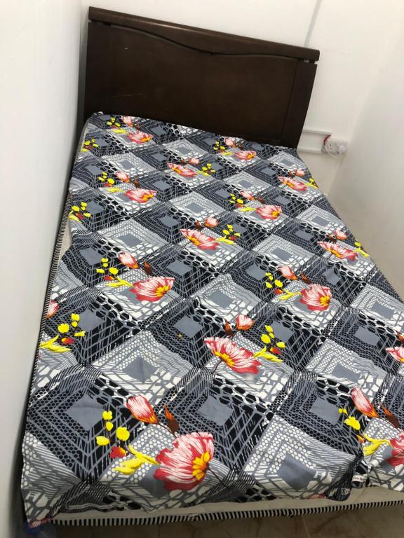 a bed with a black comforter with toy cars on it at Al Majaz Partition & Rooms in Sharjah
