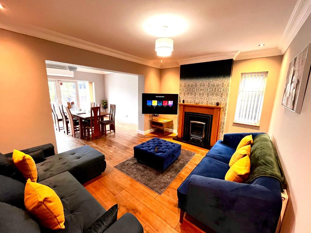 ein Wohnzimmer mit einem Sofa und einem TV in der Unterkunft Detached Home with Aircon, Patio, BBQ, Pool Table & Table Tennis in Quinton