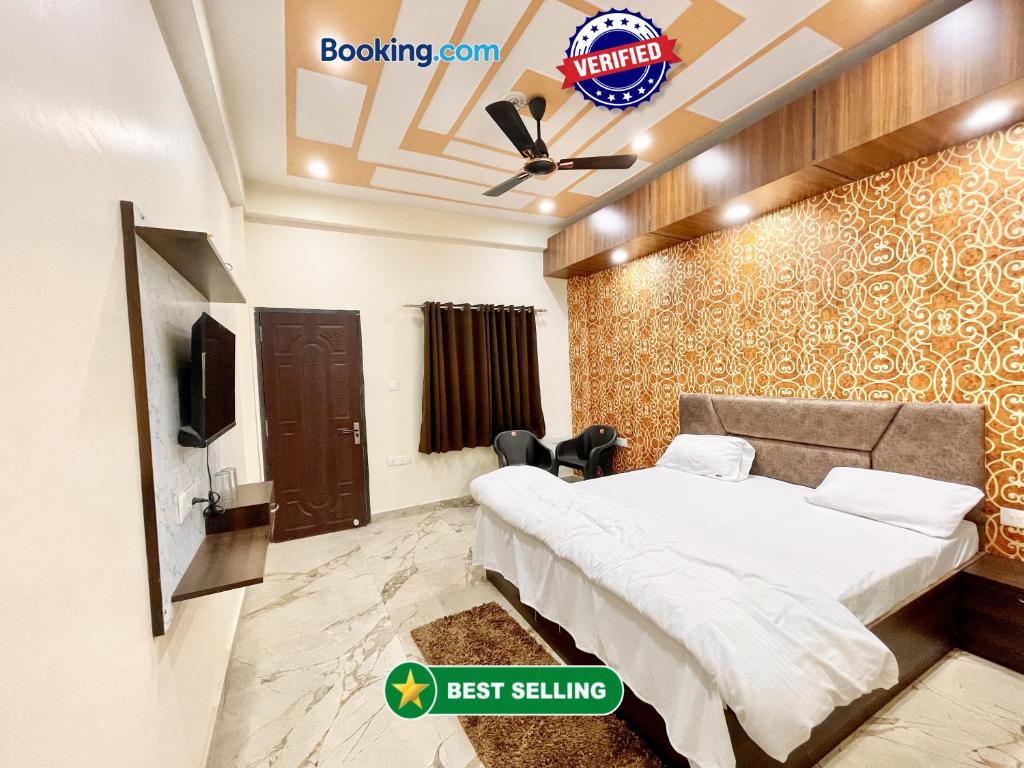a bedroom with a bed and a tv on a wall at Hotel Sunayana Guest House ! Varanasi fully-Air-Conditioned hotel at prime location, near Kashi Vishwanath Temple, and Ganga ghat in Varanasi