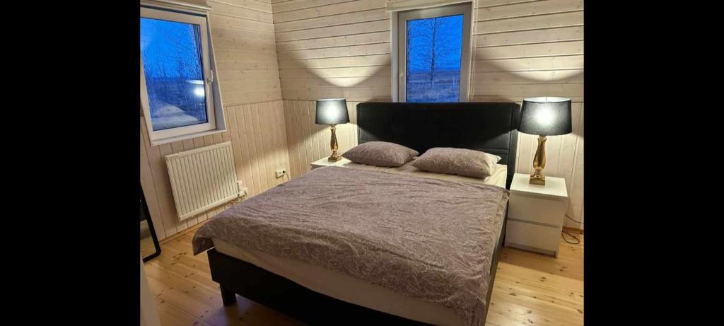 una camera con un letto e due lampade su due tavoli di Adventure Eagle Cottege a Geysir