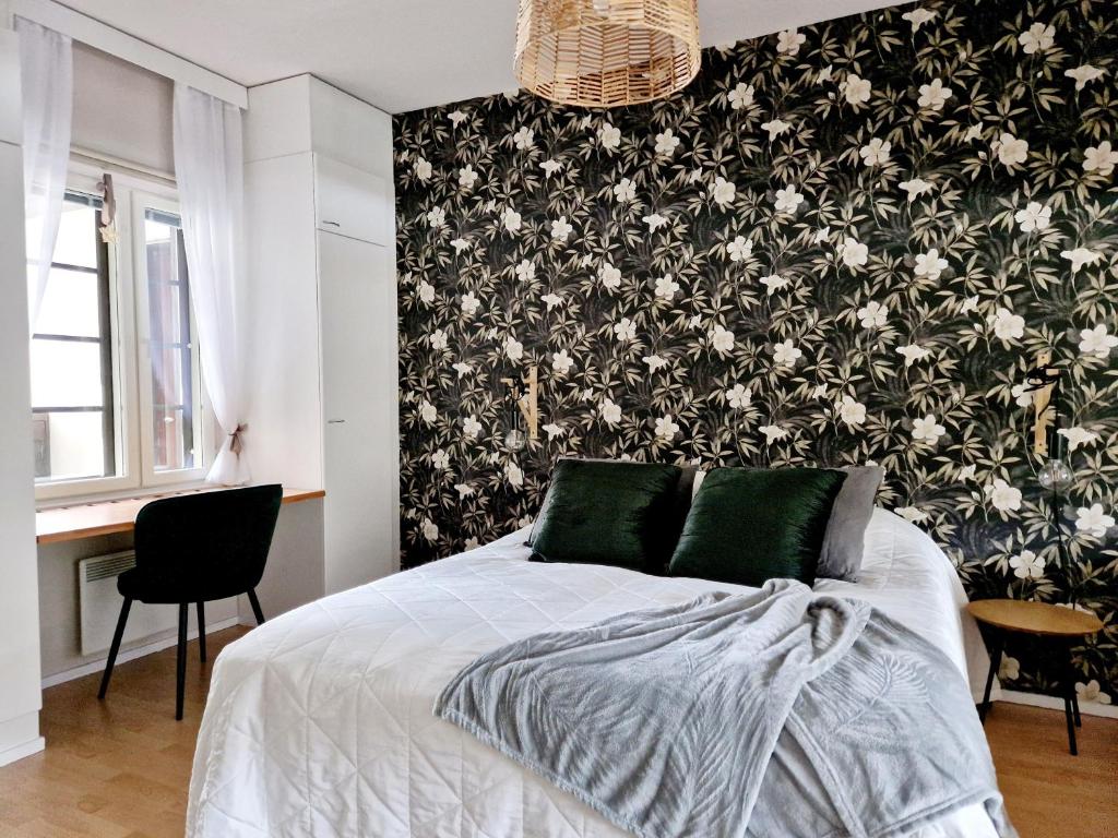 - une chambre avec un lit et du papier peint floral noir et blanc dans l'établissement Apartment Kehtola, Tahkovuori, à Kuopio