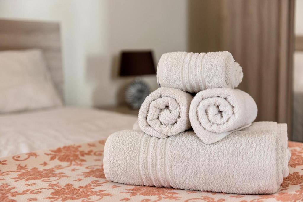 een stapel handdoeken bovenop een bed bij Mini casa in Salento in Cutrofiano