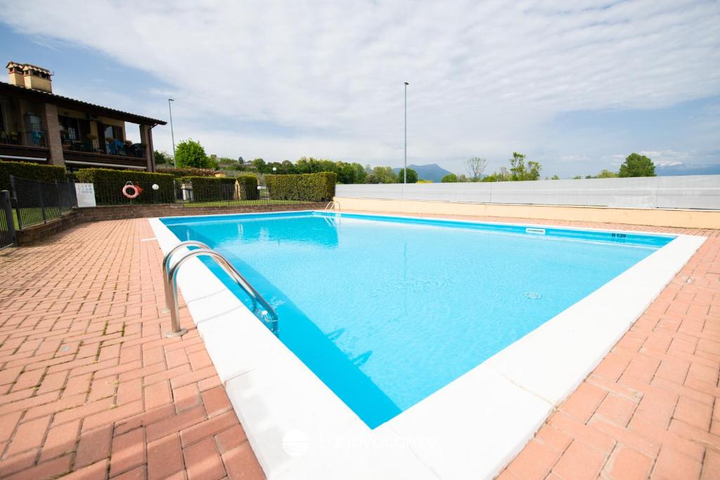een zwembad met blauw water in een gebouw bij Appartamento Stefano in Polpenazze del Garda