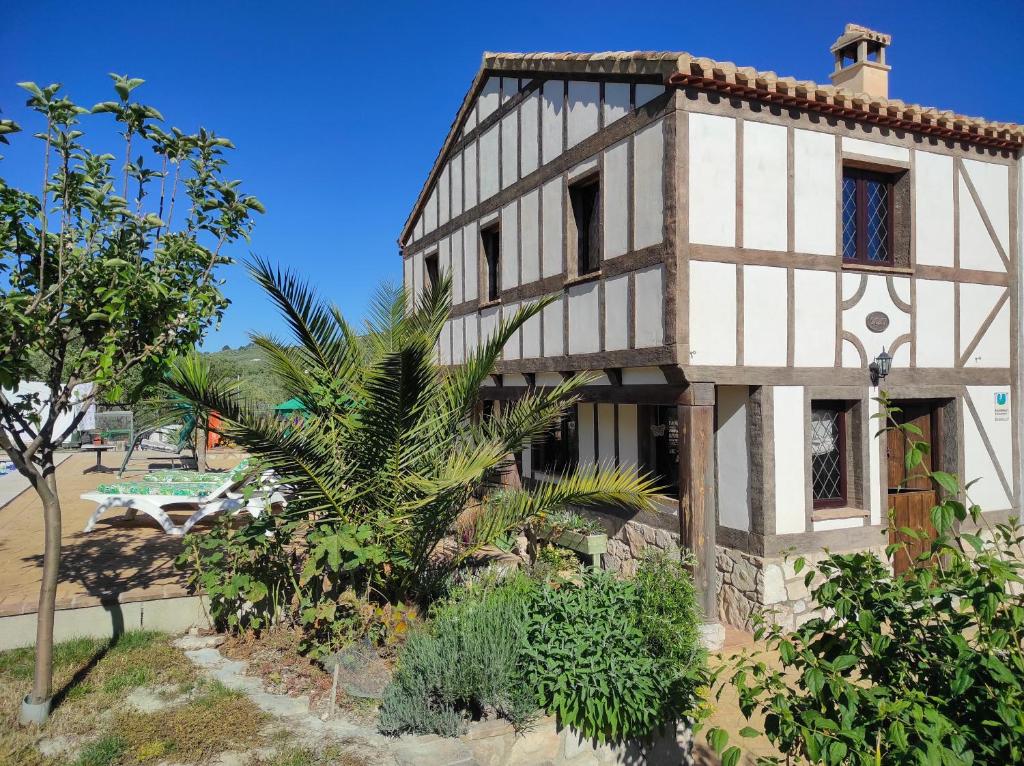 an old house with a palm tree in front of it at Las Marrojas, secluded Tudor country cottage in Algarinejo