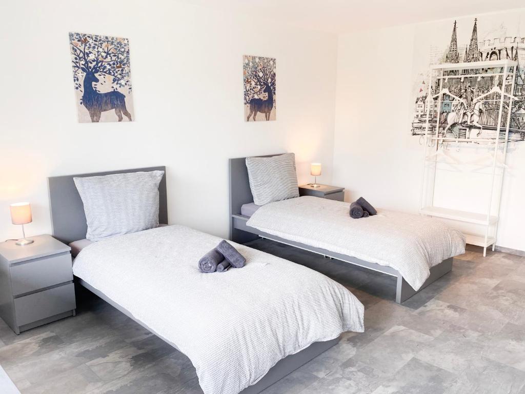 two beds in a room with white walls at Monteur- und Ferienwohnung nahe Aachen in Eschweiler