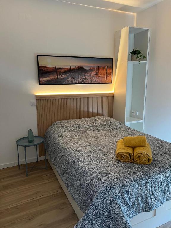 a bedroom with a bed with two yellow towels on it at Estrela da Almada Mascarenhas in Almada