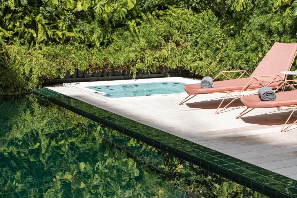 uma piscina com duas cadeiras e uma mesa e uma piscina em LUSTER Hotel em Lisboa