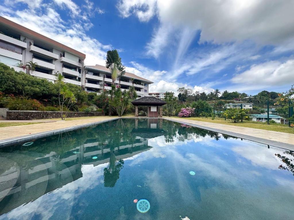 a swimming pool in front of a building at FARE MOEA - Arue (TAHITI) in Arue