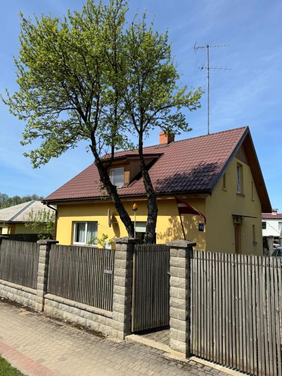a tree in a fence in front of a house at Apartment Festival Street 11 in Cēsis