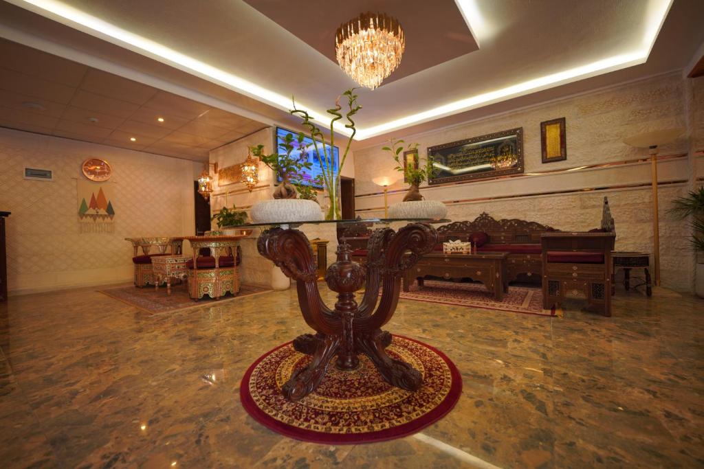a living room with a table in the middle of a room at Petra Plaza Hotel in Wadi Musa