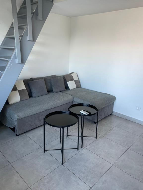 a living room with a couch and two tables at Appartement cap d'agde in Cap d'Agde