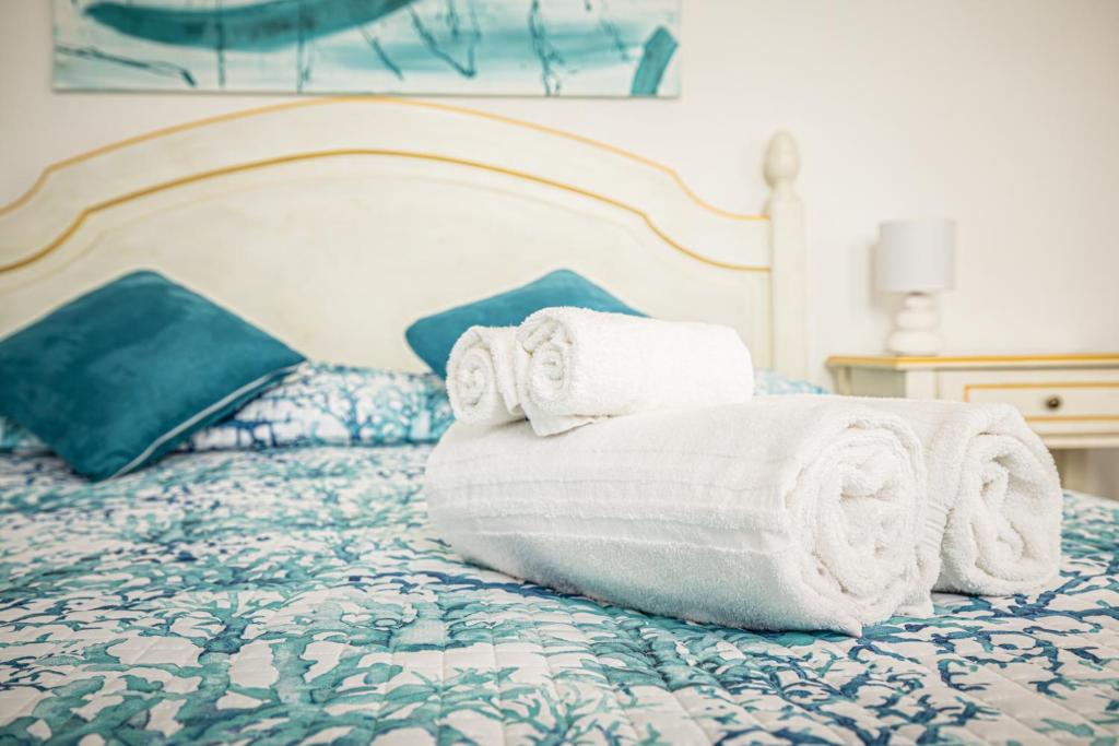 een stapel handdoeken bovenop een bed bij La Rosa Hotel - Selinunte in Marinella di Selinunte