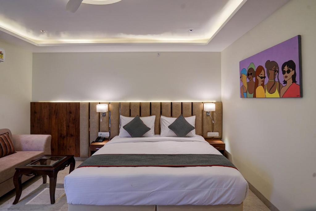 um quarto com uma cama grande e um sofá em OYO Collection O Hotel Sg Inn em Greater Noida
