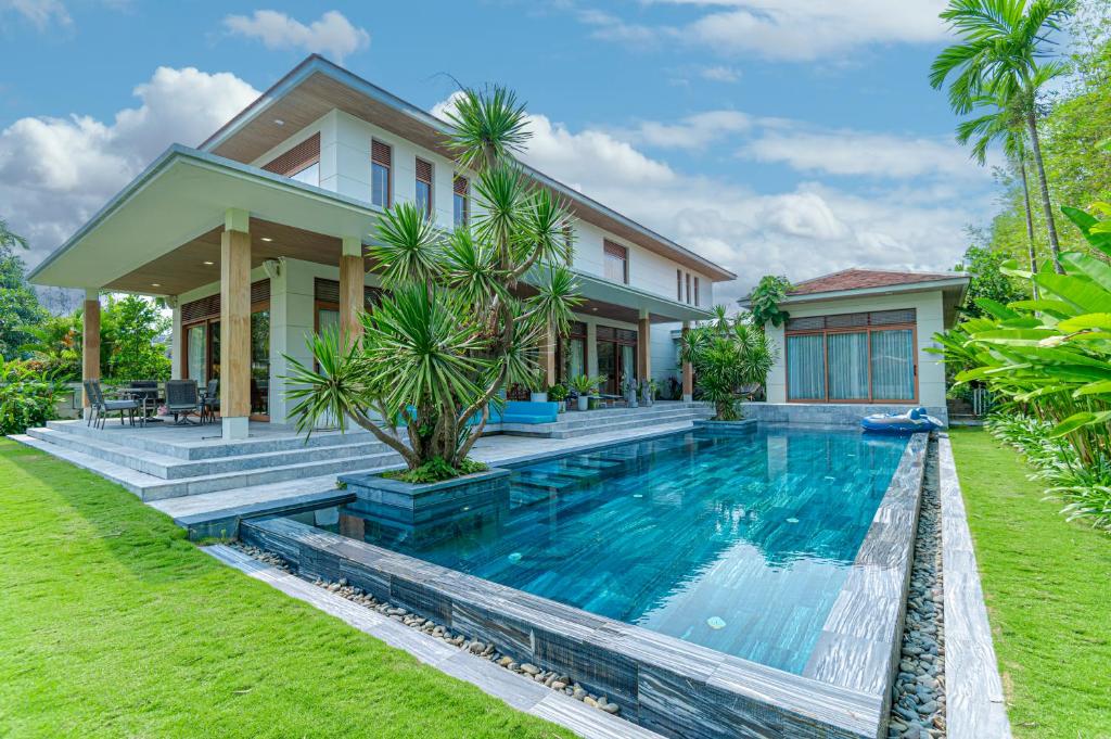 a villa with a swimming pool in front of a house at 5BedRooms Villas, Experience the luxury vacation The Ocean Estates in Da Nang