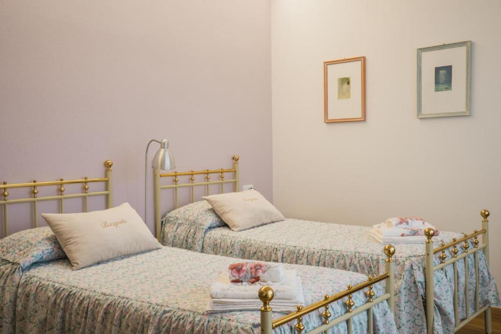 富切基奧的住宿－Lucignolo，白色墙壁客房中的两张单人床