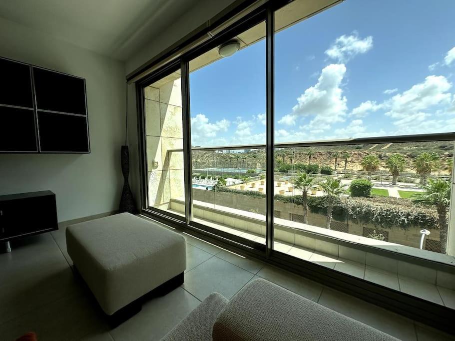 a living room with a large window with a view at Elegant 1 Bedroom Oasis Marina in Herzelia 