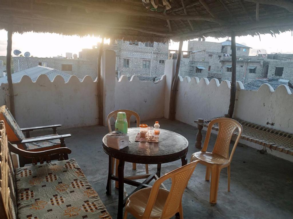 una mesa y sillas en una habitación con vistas en Tabassam Guest House, en Lamu