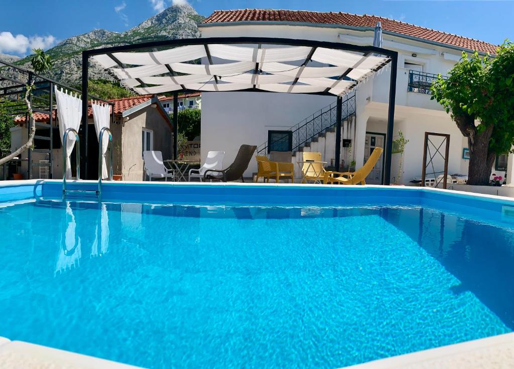 einen großen blauen Pool mit einer Pergola in der Unterkunft Summer Apartment 2 in Makarska