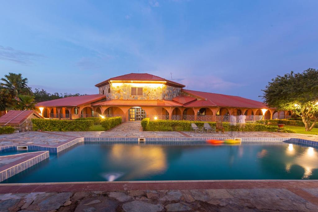 uma casa com uma piscina em frente em Mekandi Riverside Resort em Akuse