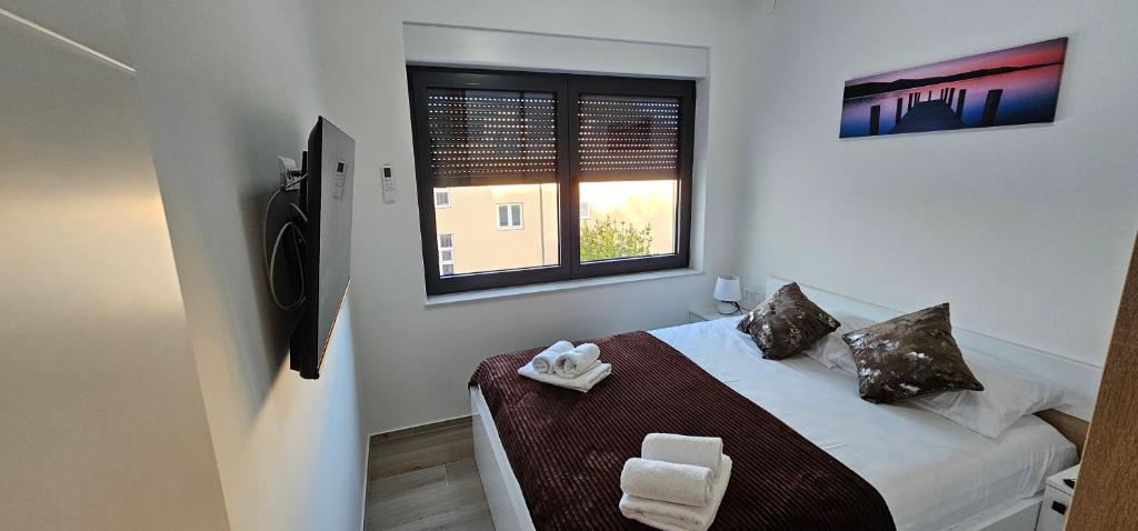 a small bedroom with a bed and a window at Vila Ibrahimovic Vodice in Vodice