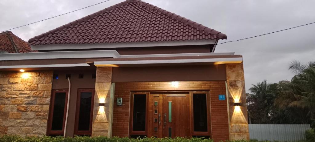 a house with a brown door and lights on it at Mutiara Homestay Jogja in Ngingas