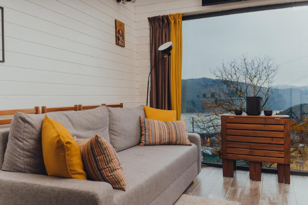 a living room with a couch and a window at Fanarele din Hangu in Hangul