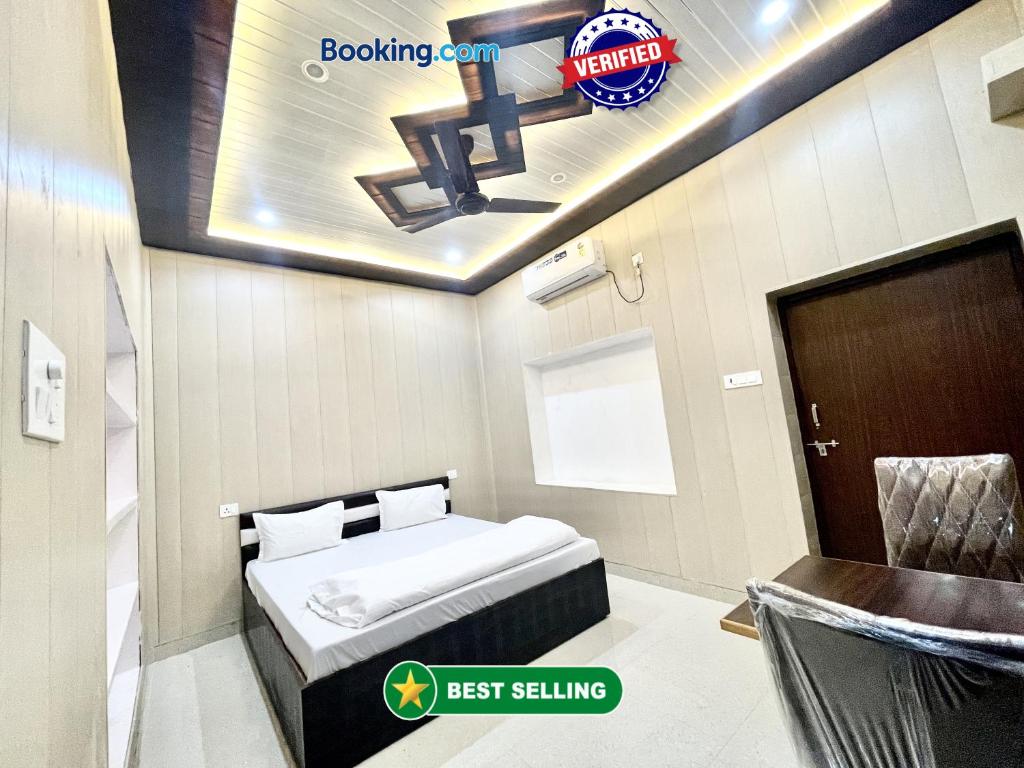 バラナシにあるHotel DEV VILLA GUEST HOUSE ! VARANASI fully-Air-Conditioned hotel at prime location, near Kashi Vishwanath Temple, and Ganga ghatのベッド、テーブル、椅子が備わる小さな客室です。