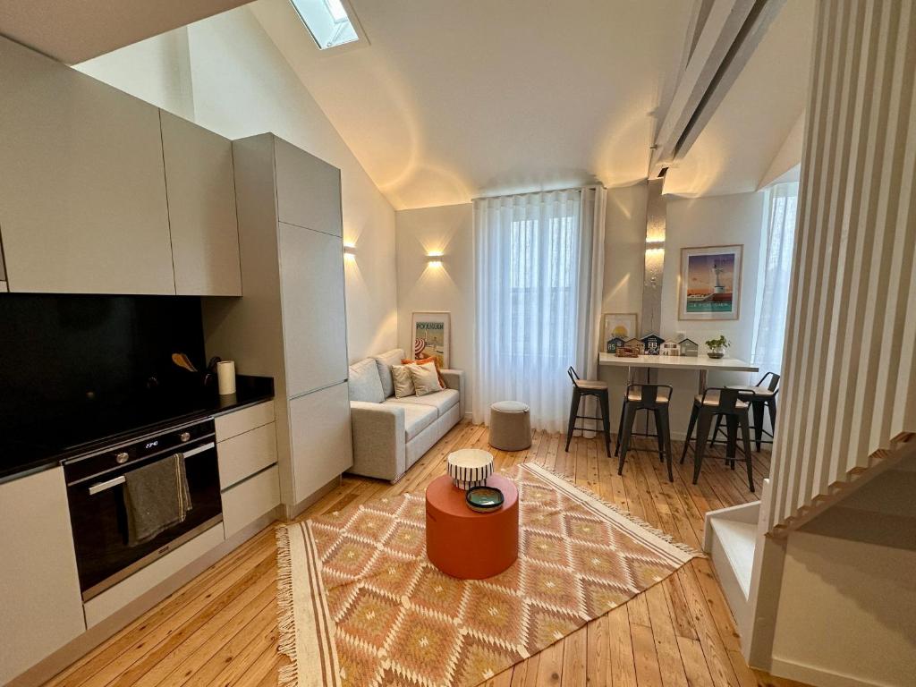 a living room with a couch and a table at Joli duplex, coeur du Pouliguen in Le Pouliguen