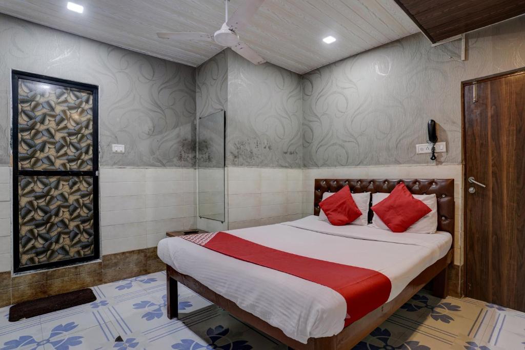 1 dormitorio con 1 cama con almohadas rojas en OYO Flagship Hotel Sapna Residency, en Bombay